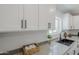 Bright kitchen features quartz countertops, a black sink, and modern white cabinetry with sleek black hardware at 346 W Edgemont Ave, Phoenix, AZ 85003