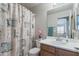 Cozy bathroom featuring a decorative shower curtain, oak vanity, and ample lighting at 3534 N 106Th Ln, Avondale, AZ 85392