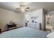 Large bedroom with a ceiling fan, wood floors, desk and access to bathroom and hall at 3534 N 106Th Ln, Avondale, AZ 85392