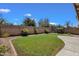 Fenced backyard with desert landscaping, grassy area and a playground structure at 4101 S Dewdrop Ct, Gilbert, AZ 85297