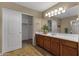 Bathroom features a wood vanity, decorative plant and large mirror with bright vanity lighting at 4101 S Dewdrop Ct, Gilbert, AZ 85297