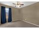 Carpeted bedroom with window features dark curtains and a ceiling fan with lighting at 4101 S Dewdrop Ct, Gilbert, AZ 85297