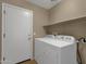 The laundry room has a washer and dryer, as well as a shelf for storing supplies at 4101 S Dewdrop Ct, Gilbert, AZ 85297