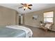 Neutral-toned bedroom with a ceiling fan, cozy chair, and plant at 4101 S Dewdrop Ct, Gilbert, AZ 85297