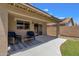 Covered patio with wicker chairs with outdoor rug overlooks landscaped backyard at 4101 S Dewdrop Ct, Gilbert, AZ 85297