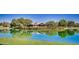 Picturesque pond reflecting the Clubhouse, surrounded by lush greenery and mature trees, creating a tranquil scene at 4101 S Dewdrop Ct, Gilbert, AZ 85297