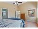 Bright bedroom features a ceiling fan and window view of outdoor patio at 4459 E Desert Wind Dr, Phoenix, AZ 85044