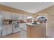 Charming kitchen with white cabinetry, stainless steel appliances, and a breakfast bar overlooking backyard at 4459 E Desert Wind Dr, Phoenix, AZ 85044