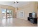 Bright and open living room with tile floors, sliding glass doors to backyard, and a ceiling fan at 4459 E Desert Wind Dr, Phoenix, AZ 85044