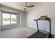 Carpeted bedroom with ceiling fan, window, and treadmill for exercise and recreation at 509 W Villa Rita Dr, Phoenix, AZ 85023