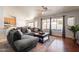 Cozy living room with dark wood floors, a large sectional sofa, and views of the pool at 509 W Villa Rita Dr, Phoenix, AZ 85023