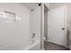 All-white tiled shower and bath featuring a tiled niche, providing a fresh and modern bathing experience at 533 E 7Th Pl, Mesa, AZ 85203