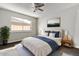Inviting bedroom with a ceiling fan, large window, and a queen-sized bed adorned with stylish blue accents at 533 E 7Th Pl, Mesa, AZ 85203