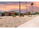 Single-story brick home with desert landscaping, arched windows, and tall palm trees with a colorful sky at 533 E 7Th Pl, Mesa, AZ 85203