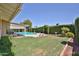 Spacious backyard with a pool, manicured lawn, and privacy hedges perfect for outdoor entertaining at 5349 W Acapulco Ln, Glendale, AZ 85306
