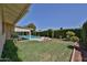 Lush backyard oasis with a sparkling pool, well-manicured lawn, mature landscaping, and a covered patio at 5349 W Acapulco Ln, Glendale, AZ 85306