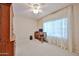 This bedroom has neutral walls and carpet, a ceiling fan and a dark wood desk and storage cabinet at 5349 W Acapulco Ln, Glendale, AZ 85306