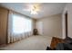 Bedroom features a ceiling fan, carpet, and a white framed window with a lace curtain at 5349 W Acapulco Ln, Glendale, AZ 85306