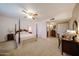 Large primary bedroom with a four poster bed, and a nearby ensuite bath and walk-in closet at 5349 W Acapulco Ln, Glendale, AZ 85306