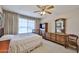 This bedroom features neutral walls and carpet, a ceiling fan and dark wood furnishings at 5349 W Acapulco Ln, Glendale, AZ 85306