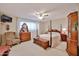 Comfortable bedroom features a four-poster bed, vintage furniture, and bright natural light at 5349 W Acapulco Ln, Glendale, AZ 85306