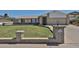 Inviting front yard with lush lawn, desert landscaping, and an elegant brick planter at 5349 W Acapulco Ln, Glendale, AZ 85306