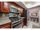 Updated kitchen featuring stainless steel appliances, granite countertops, and cherry wood cabinets at 5349 W Acapulco Ln, Glendale, AZ 85306