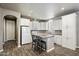 Bright kitchen with white cabinetry, an island with seating, and wood-look flooring at 650 N Hawes Rd # 3424, Mesa, AZ 85207