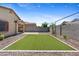 Beautiful backyard with desert landscaping, a covered patio, and a lush artificial turf area at 654 E Buckingham Ave, Gilbert, AZ 85297