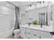 Bright bathroom featuring a double sink vanity, tile floors, and a shower with curtain at 654 E Buckingham Ave, Gilbert, AZ 85297