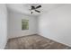 A well-lit bedroom features a neutral carpet, ceiling fan and a large window at 654 E Buckingham Ave, Gilbert, AZ 85297