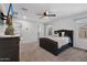Bright bedroom with a tufted headboard bed, a ceiling fan, and a wall-mounted TV at 654 E Buckingham Ave, Gilbert, AZ 85297