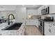 Bright kitchen features granite countertops, stainless steel appliances and wood tile flooring at 654 E Buckingham Ave, Gilbert, AZ 85297