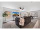 Spacious living room featuring a large sofa, TV, and a view of the dining area and backyard at 654 E Buckingham Ave, Gilbert, AZ 85297