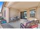 Covered patio area with outdoor seating including chairs, a bench, and a small table at 654 E Buckingham Ave, Gilbert, AZ 85297