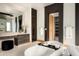 Bright bathroom features modern soaking tub, stone floors, large mirror and vanity, and access to walk-in closet at 6702 E Cholla St, Scottsdale, AZ 85254