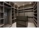 Spacious walk-in closet featuring custom wood cabinetry and drawers with a glass display top at 6702 E Cholla St, Scottsdale, AZ 85254