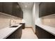 Clean laundry room featuring custom wood cabinetry, modern sink, countertops, and tiled backsplash at 6702 E Cholla St, Scottsdale, AZ 85254