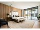 Spacious main bedroom with wood accent wall, plush furnishings, and outdoor pool view at 6702 E Cholla St, Scottsdale, AZ 85254