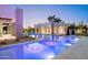 Stunning pool with in-water lounge chairs and umbrella in a modern backyard at twilight at 6702 E Cholla St, Scottsdale, AZ 85254