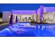 Modern in-pool chaise lounges featuring colorful lighting and views of the home and covered patio at 6702 E Cholla St, Scottsdale, AZ 85254