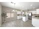 Bright kitchen with white cabinets, stainless steel appliances, an island, and a dining area by a large window at 6712 W Northview Ave, Glendale, AZ 85303