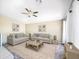 Airy living room with vaulted ceilings, ceiling fan, and two matching sofas on a patterned rug and white flooring at 6712 W Northview Ave, Glendale, AZ 85303