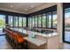 A bar with modern countertops, bright orange chairs, and retracting windows overlooking the well-maintained grounds at 7878 E Gainey Ranch Rd # 36, Scottsdale, AZ 85258