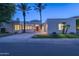 Stunning modern home exterior at dusk with lush landscaping and a circular driveway at 7878 E Gainey Ranch Rd # 36, Scottsdale, AZ 85258