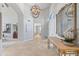 Elegant foyer with tiled flooring, high ceiling, designer chandelier and ornate mirror at 7878 E Gainey Ranch Rd # 36, Scottsdale, AZ 85258