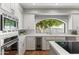 Bright kitchen with white cabinets, built in stainless appliances, quartz countertops and a garden view at 7878 E Gainey Ranch Rd # 36, Scottsdale, AZ 85258