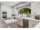 Bright kitchen with white cabinets, stainless steel appliances, quartz countertops and a garden view at 7878 E Gainey Ranch Rd # 36, Scottsdale, AZ 85258