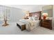 Bedroom featuring a decorative headboard, side tables with lamps, bench, and plantation shutters at 7878 E Gainey Ranch Rd # 36, Scottsdale, AZ 85258