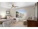 Bright bedroom with two twin beds, ceiling fan, large window with views, and dark wood furniture at 8958 W Rosemonte Dr, Peoria, AZ 85382